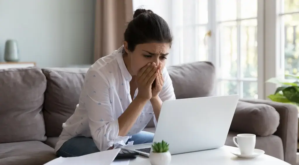 mulher desesperada a frente do notebook